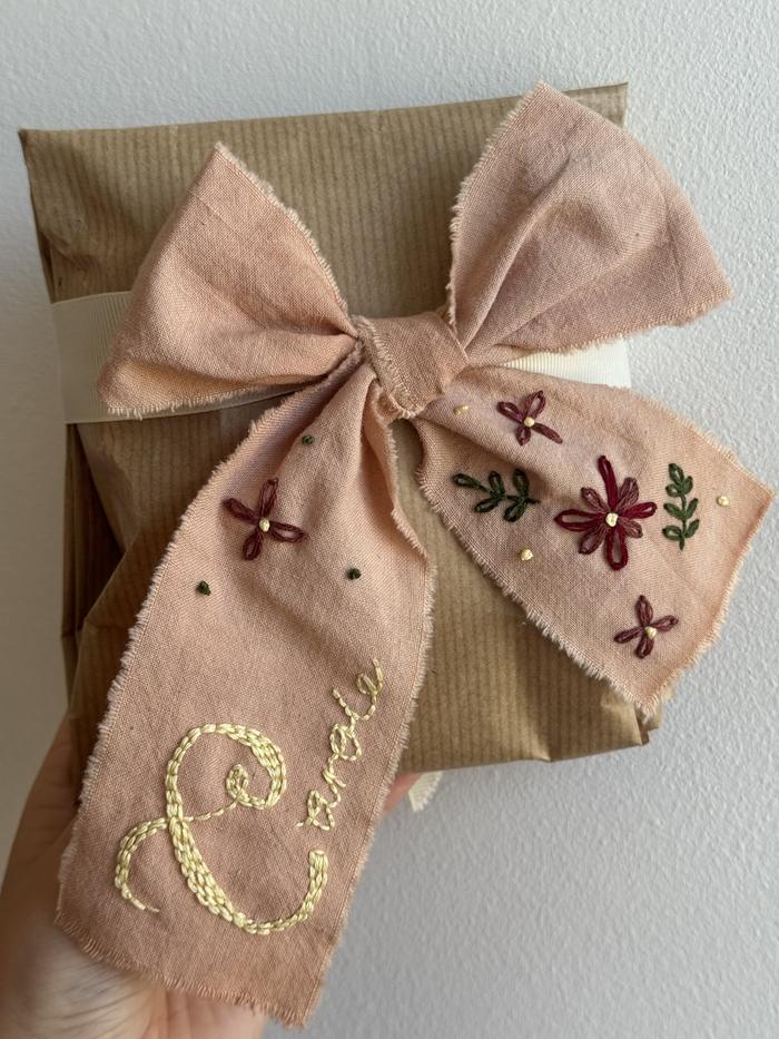 Custom hand-embroidered ribbon on naturally dyed cotton with floral motifs