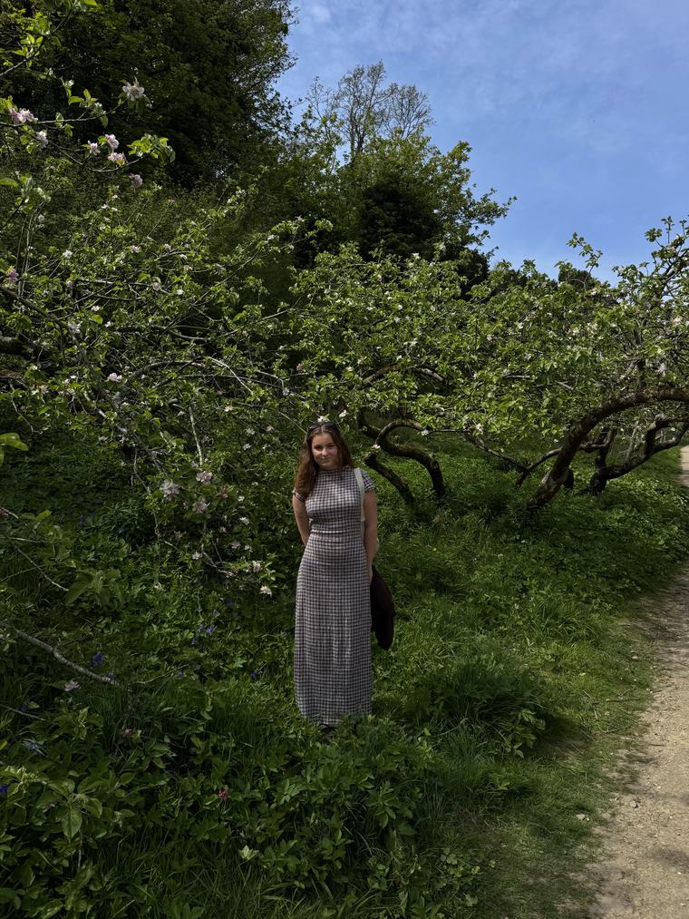 Manon Bower standing beneath apple blossom in Brighton